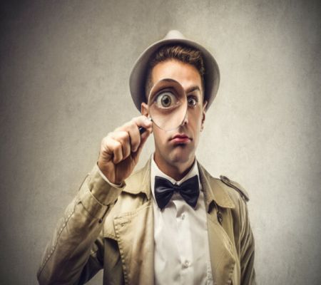 man with magnifying glass against his eye